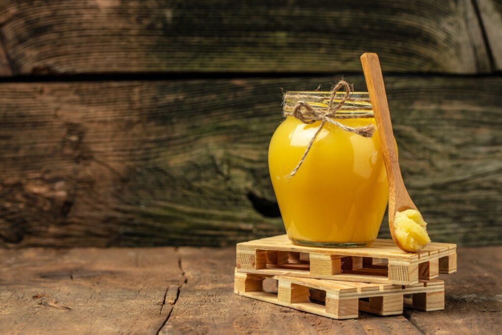 Ghee or clarified butter in jar on a wooden background. Credit: shutterstock