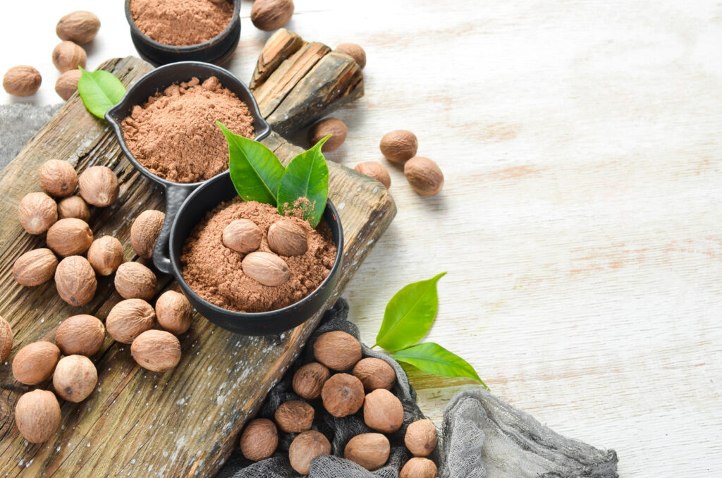 Ground nutmeg in bowls on a white background. Indian spices. Image Via Shutterstock