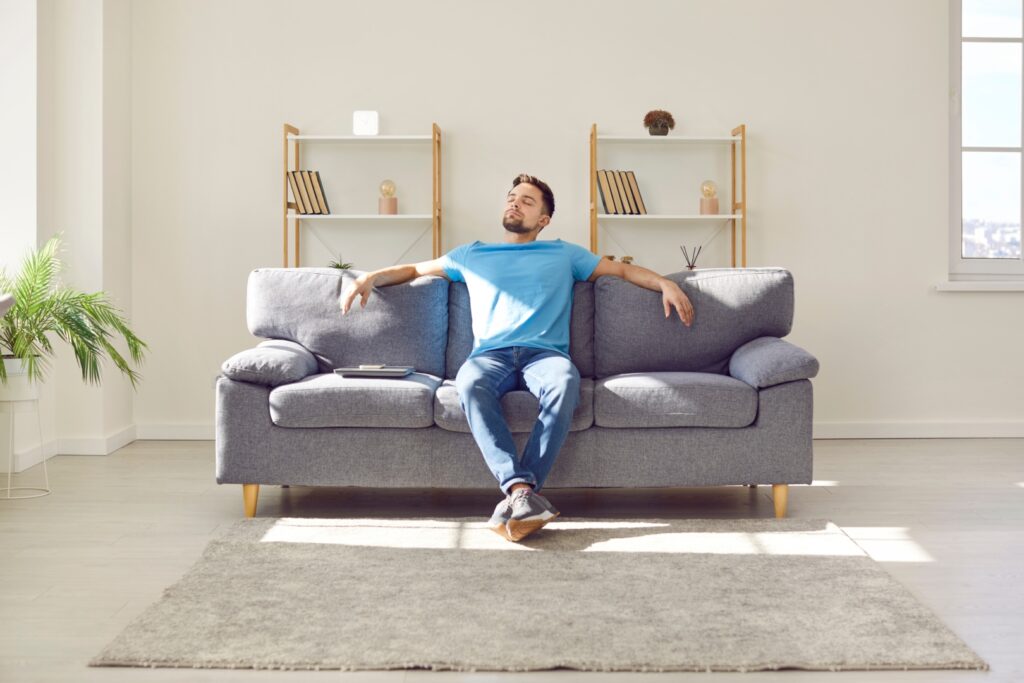 Young man relaxing on couch. Image via Shutterstock